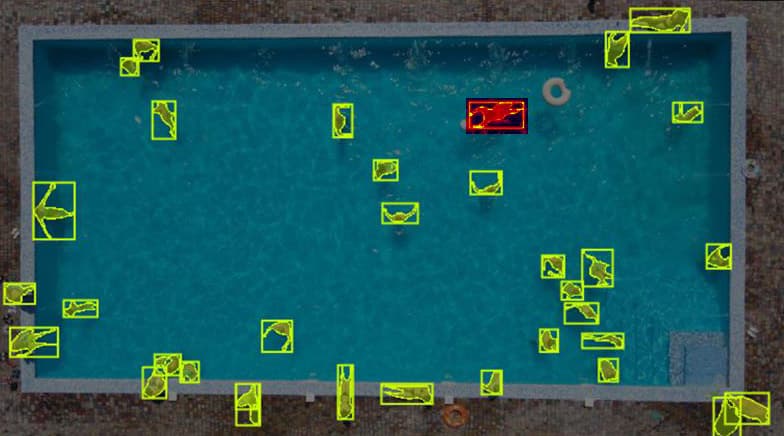 AI-analyzed pool feed with detection bounding boxes on swimmers and distress alert